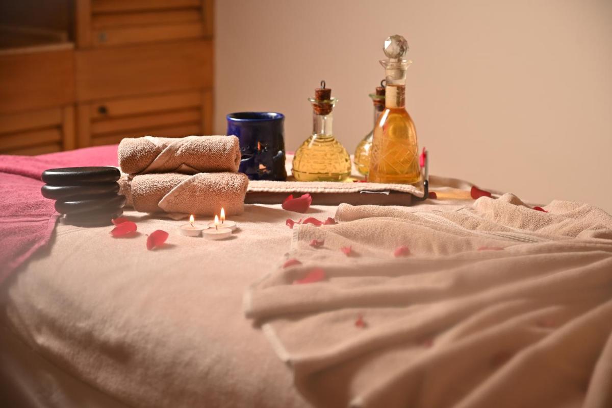 a bed with some candles and bottles on it at The Grand New Delhi in New Delhi a bed with some candles and bottles on it at The Grand New Delhi in New Delhi