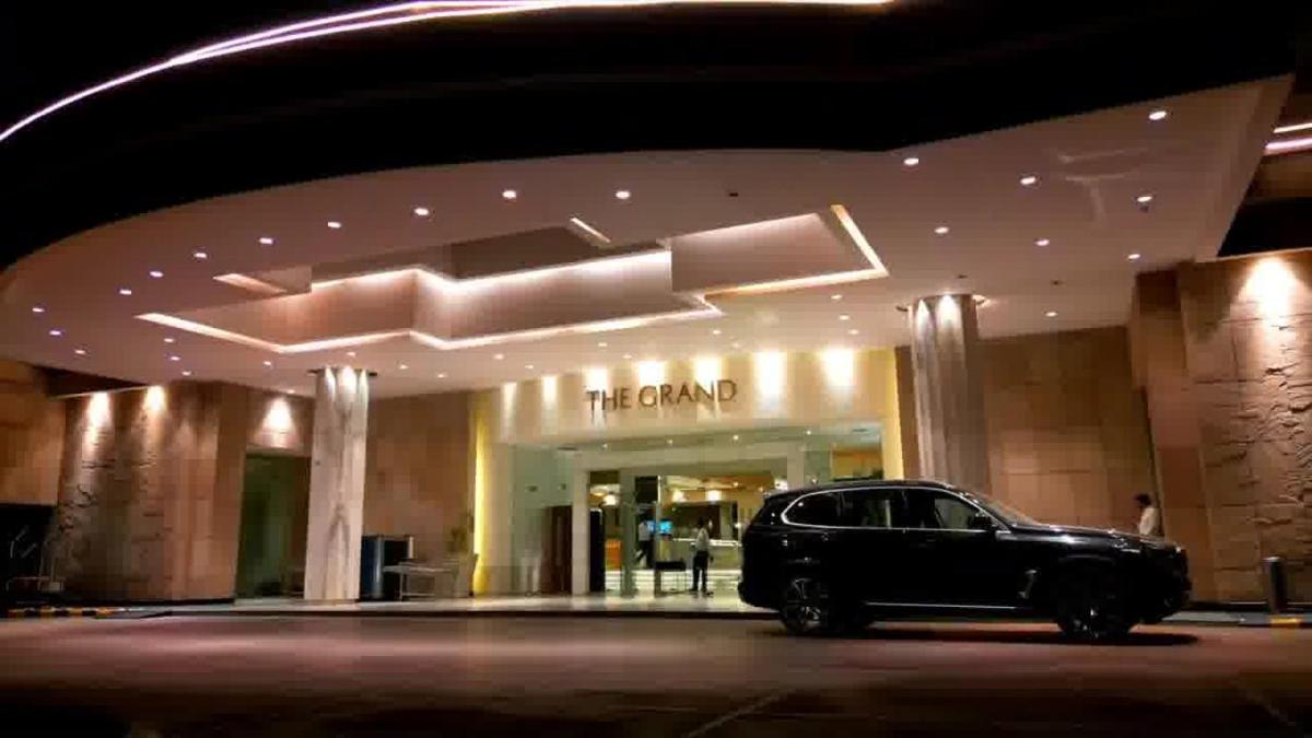a black car parked in front of a hotel at The Grand New Delhi in New Delhi a black car parked in front of a hotel at The Grand New Delhi in New Delhi