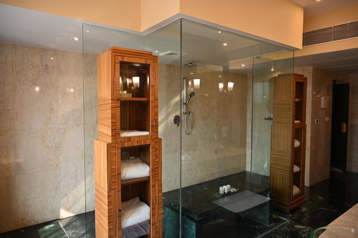 a bathroom with a shower and a sink at The Grand New Delhi in New Delhi a bathroom with a shower and a sink at The Grand New Delhi in New Delhi