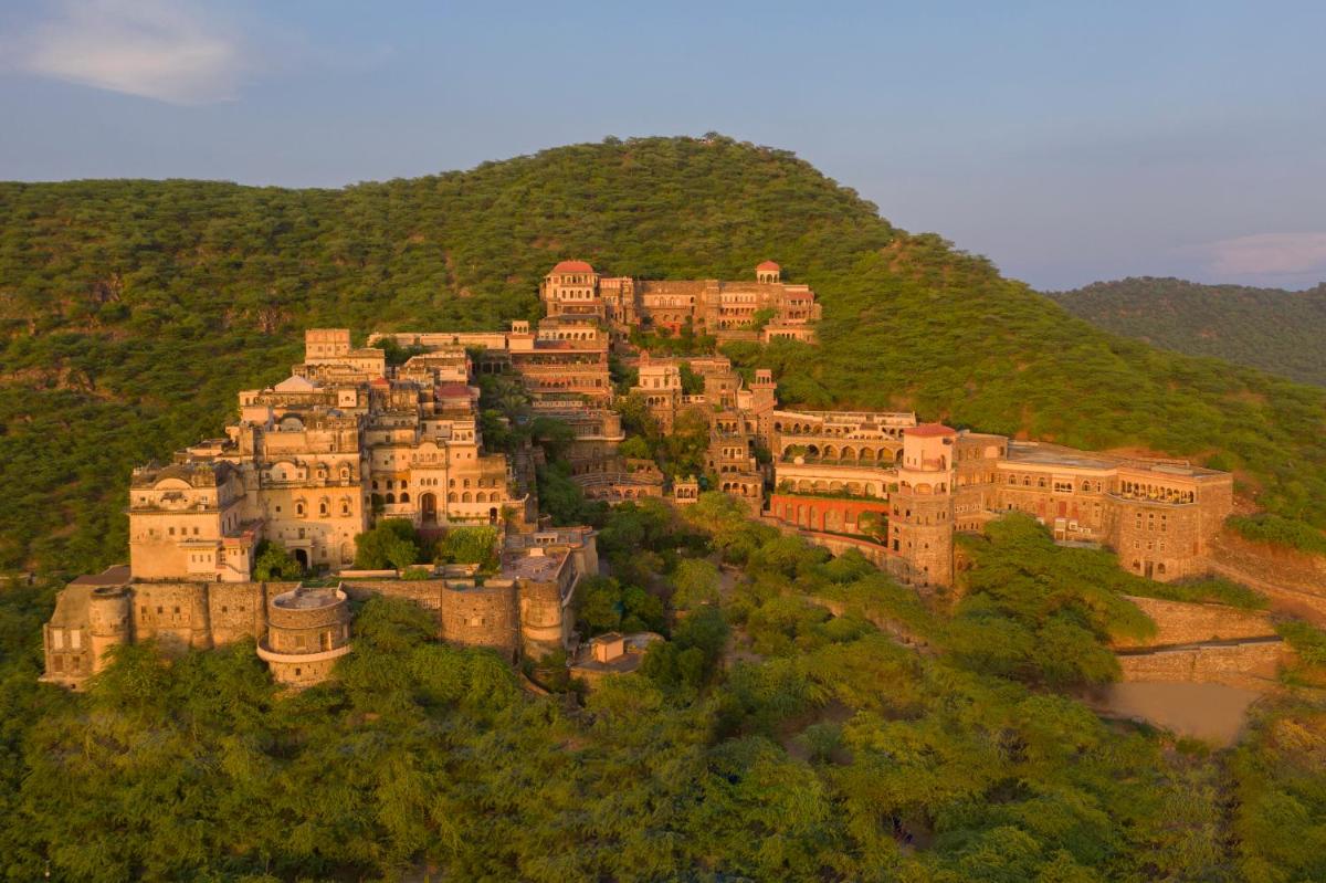 a castle on top of a hill with trees at Neemrana Fort-Palace in Neemrana