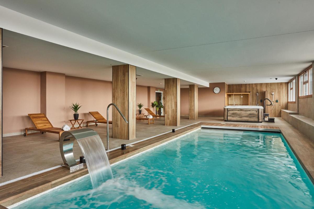 una piscina con agua en una habitación de hotel en Apartamentos Silken Fontibre Iberia & Spa, en Nestares