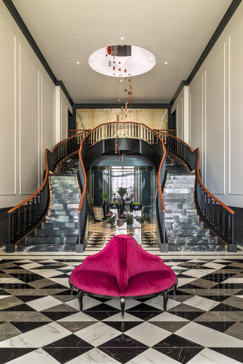uma grande escada com um tapete rosa no chão em Amoure Hotel - The Leading Hotels of the World em Braga