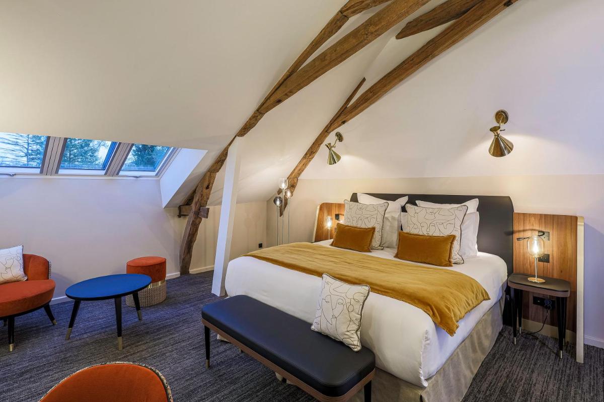 une chambre avec un grand lit et une chaise dans l'établissement Château de Maraval, à Cénac-et-Saint-Julien