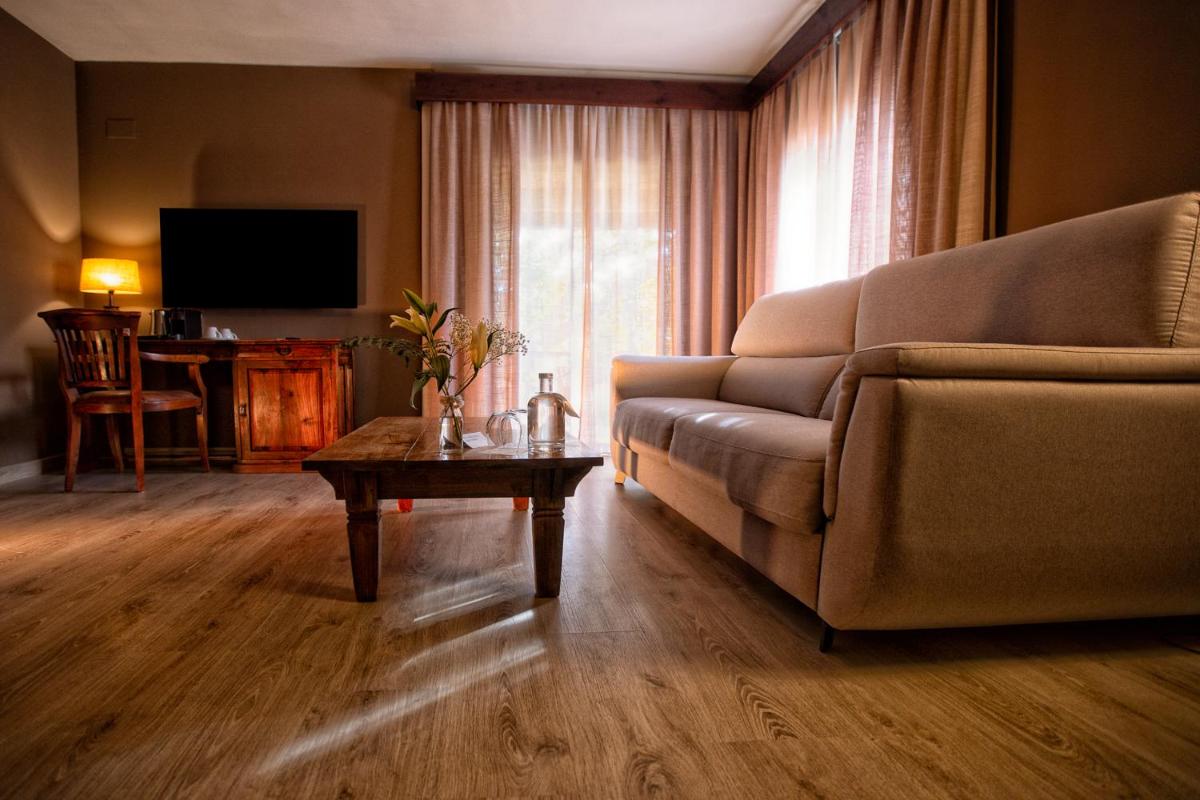 una sala de estar con un sofá y una mesa en SWISS MORAIRA HOTEL & SPA - Adults only, en Moraira