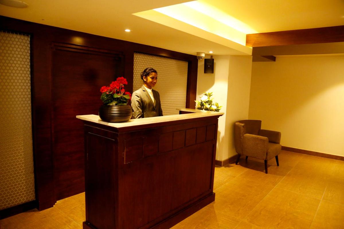 a man sitting at a bar in a hotel room at The Raviz Calicut in Kozhikode