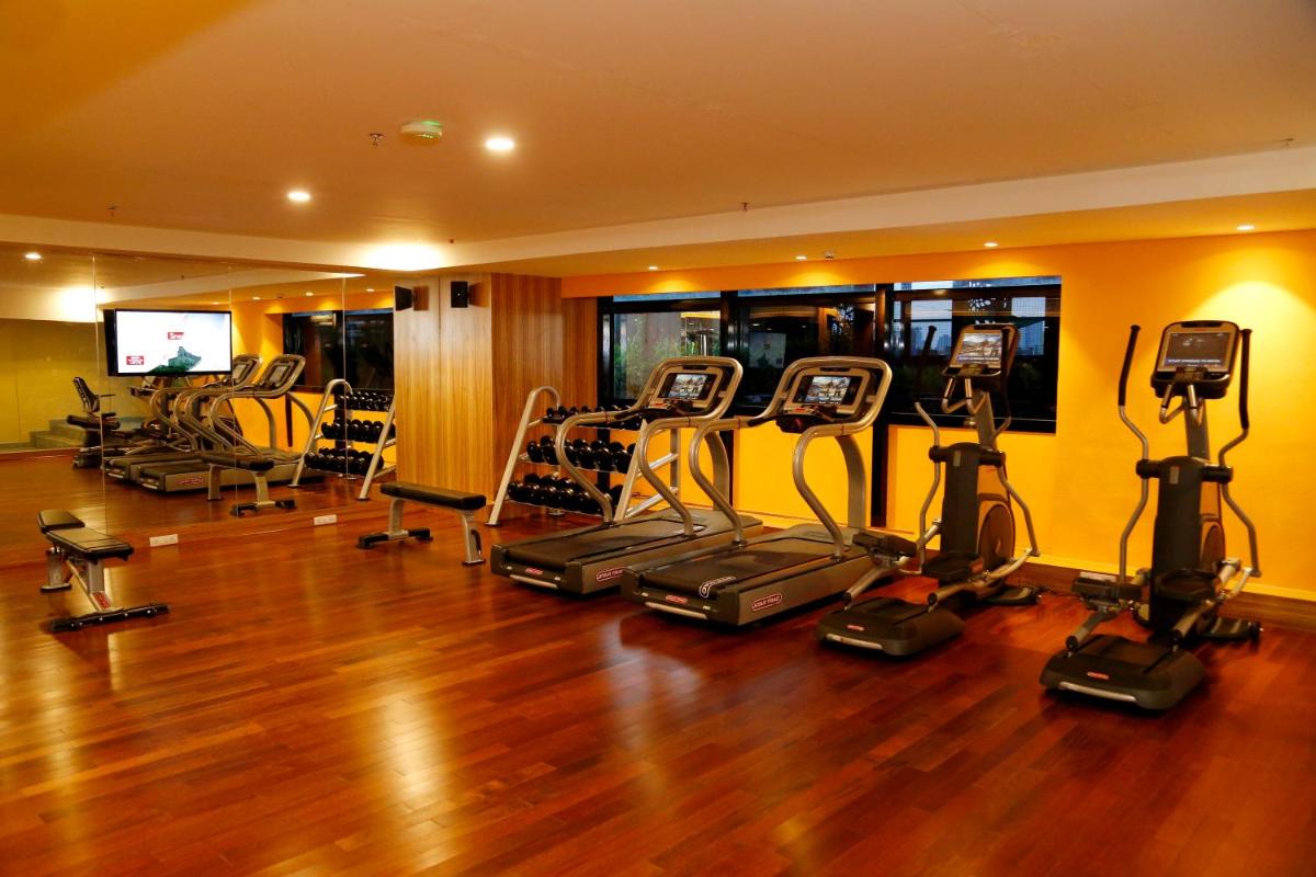 a gym with a bunch of cardio equipment in a room at The Raviz Calicut in Kozhikode
