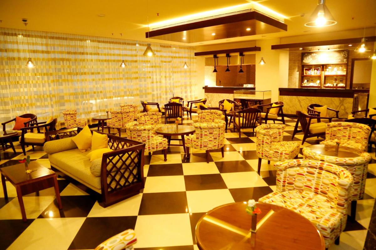 a restaurant with couches and tables and a checkered floor at The Raviz Calicut in Kozhikode