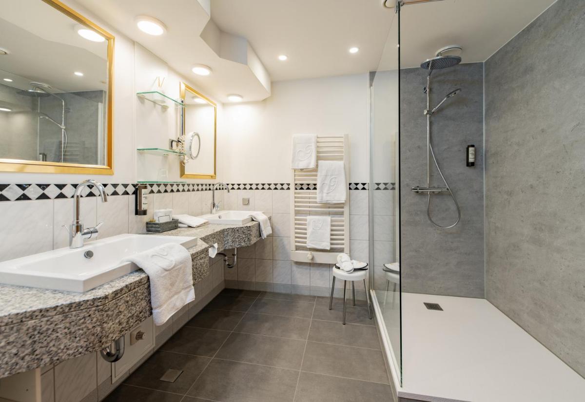 ein Badezimmer mit Badewanne, Waschbecken und Dusche in der Unterkunft Göbels Schlosshotel "Prinz von Hessen" in Friedewald ein Badezimmer mit Badewanne, Waschbecken und Dusche in der Unterkunft Göbels Schlosshotel "Prinz von Hessen" in Friedewald