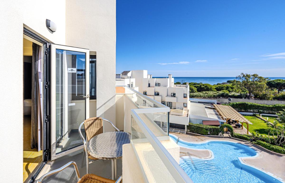 uma varanda com vista para uma piscina e para o oceano em Santa Eulalia Hotel & Spa em Albufeira