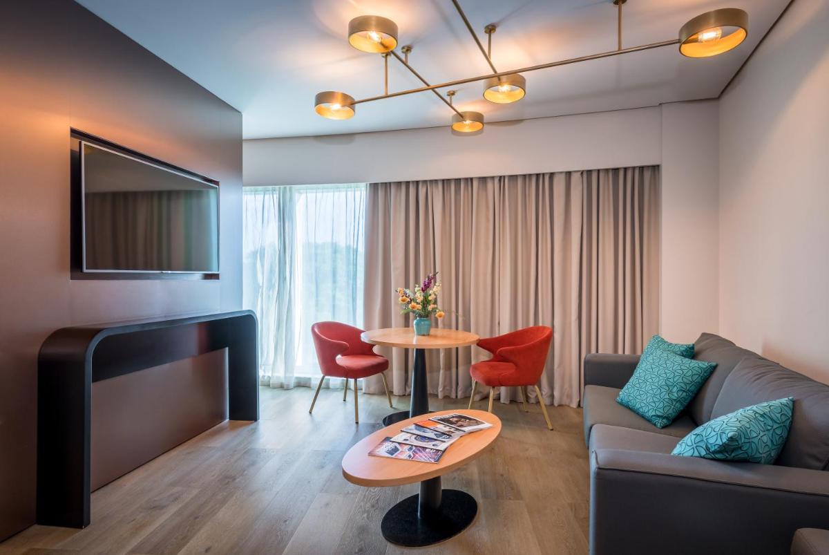 una sala de estar con un sofá y una mesa en Barceló Sevilla Renacimiento, en Sevilla