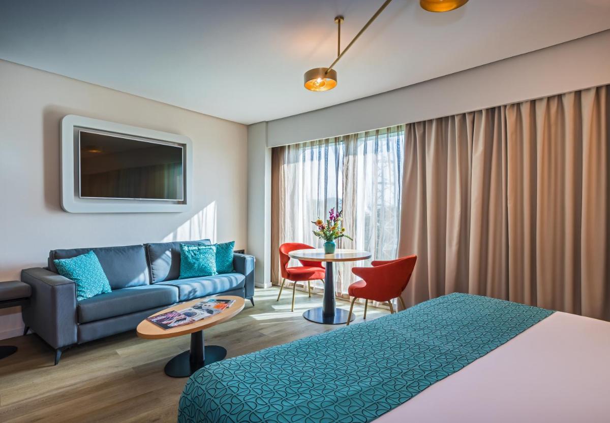 una habitación de hotel con una cama y un sofá en Barceló Sevilla Renacimiento, en Sevilla