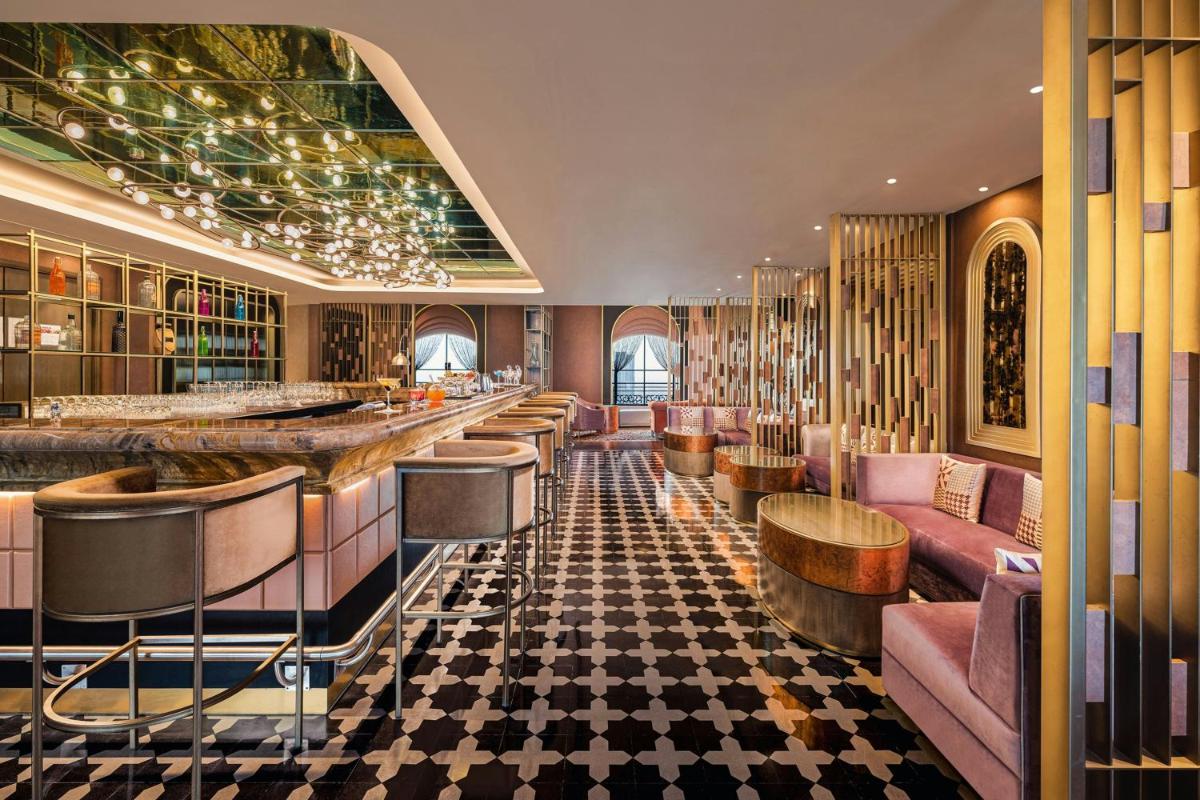 a bar in a hotel with pink chairs and a counter at ITC Royal Bengal, a Luxury Collection Hotel, Kolkata in Kolkata