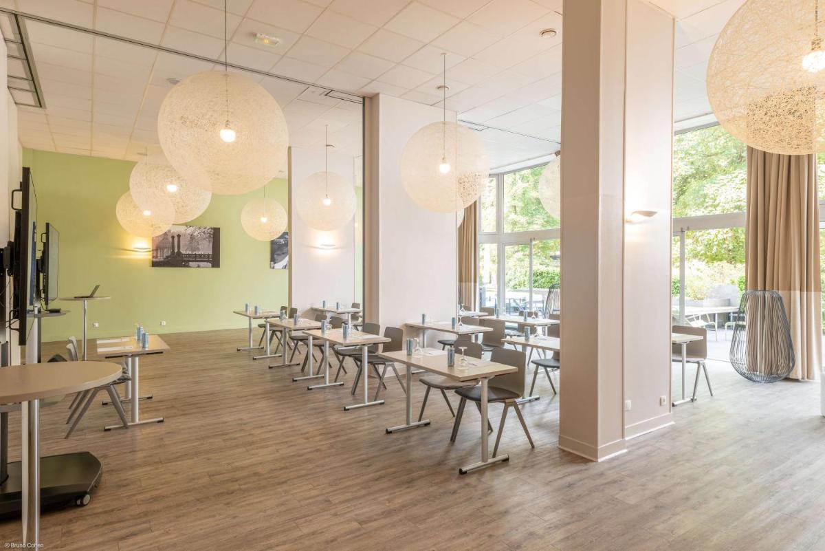une salle à manger avec tables, chaises et lustres dans l'établissement Best Western Plus Hotel Du Parc Chantilly, à Chantilly