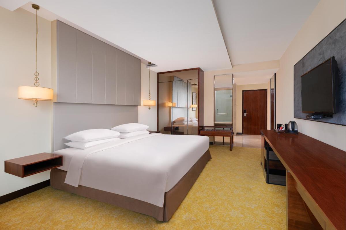 a hotel room with a bed and a television at Renaissance Ahmedabad Hotel in Ahmedabad
