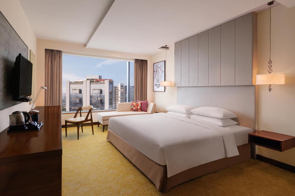 a hotel room with a bed and a large window at Renaissance Ahmedabad Hotel in Ahmedabad