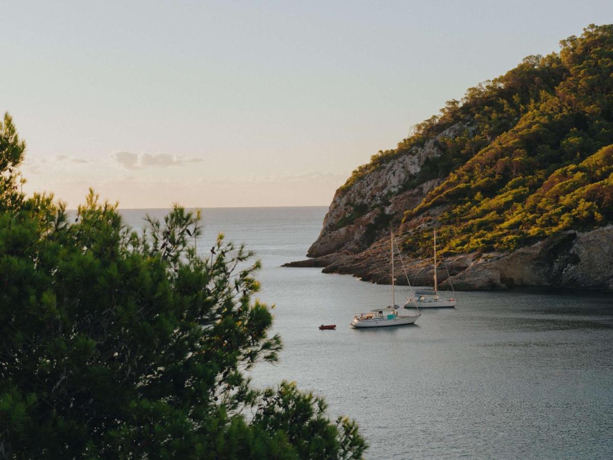 dos barcos están atracados en un cuerpo de agua en Mondrian Ibiza, en Cala Llonga