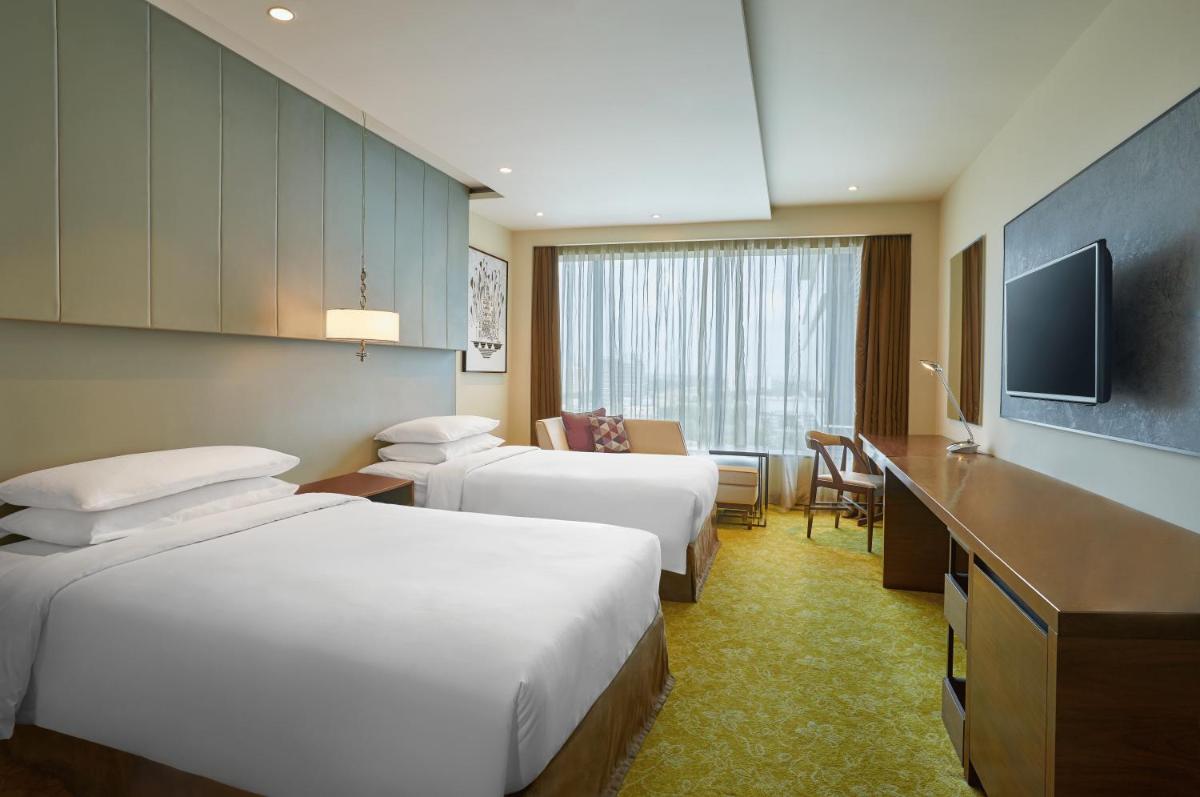 a hotel room with two beds and a television at Renaissance Ahmedabad Hotel in Ahmedabad