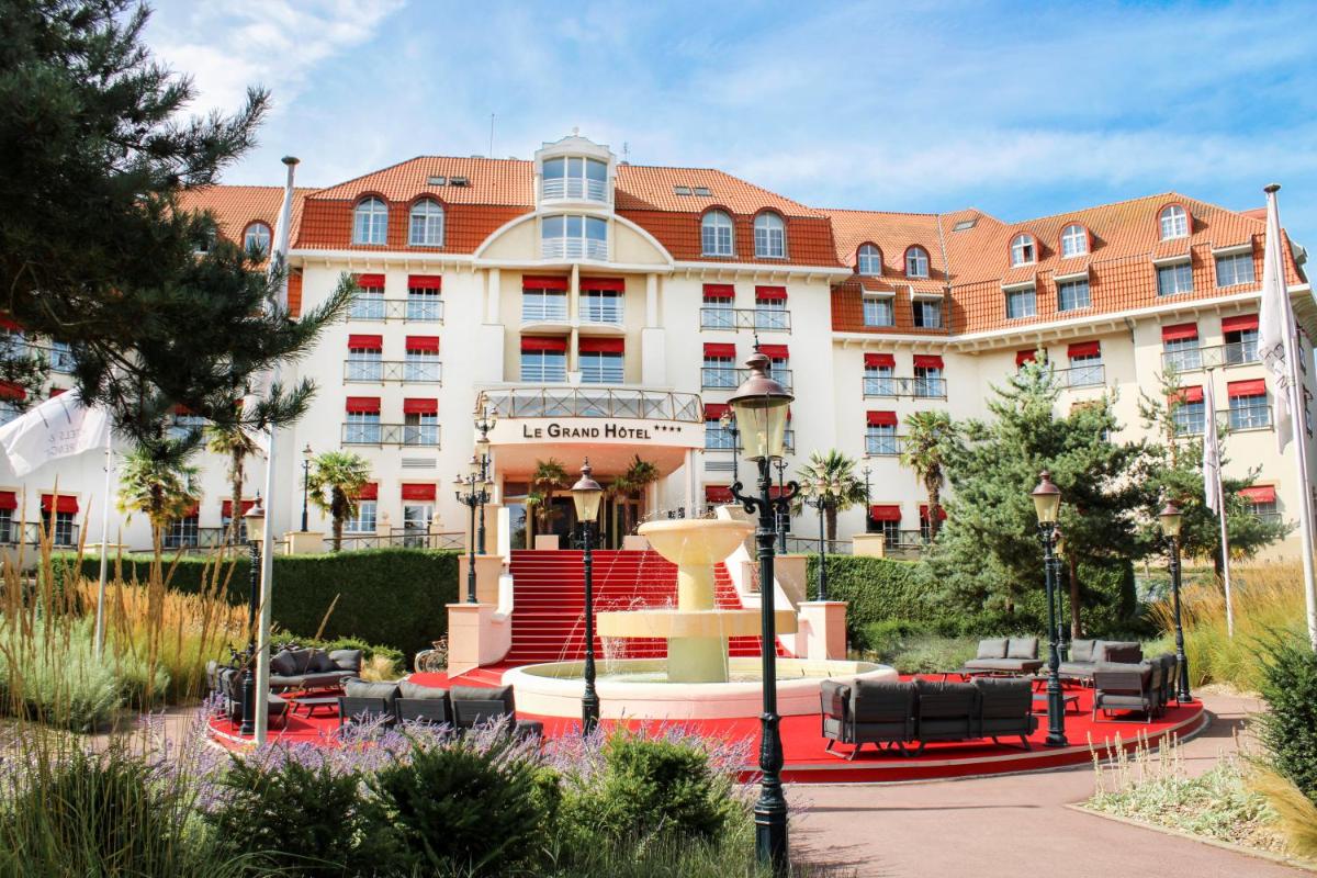 un grand bâtiment avec une fontaine devant lui dans l'établissement Le Grand Hôtel Le Touquet-Paris-Plage, à Le Touquet-Paris-Plage