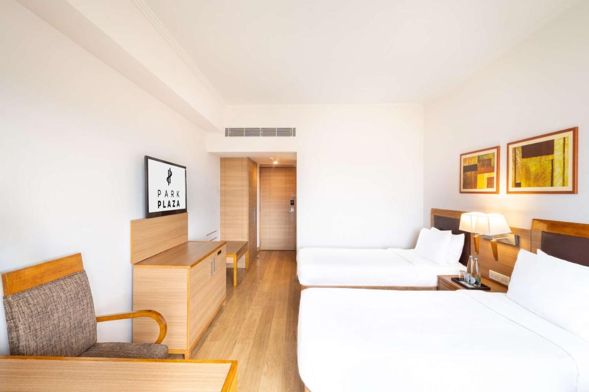 a hotel room with a bed and a chair at Park Plaza Chennai OMR in Chennai
