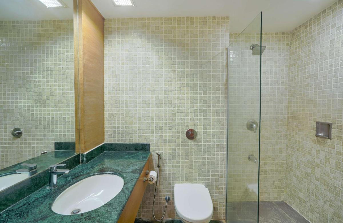 a bathroom with a sink and a shower and a toilet at Park Plaza Chennai OMR in Chennai
