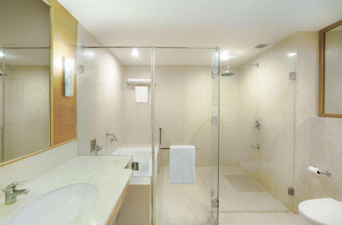 a bathroom with a glass shower and a sink at Park Plaza Chennai OMR in Chennai