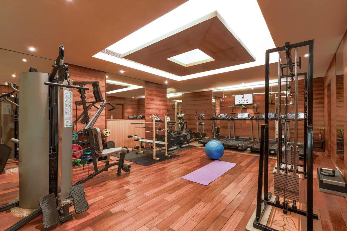 a gym with several tread machines and a blue ball at Park Plaza Chennai OMR in Chennai