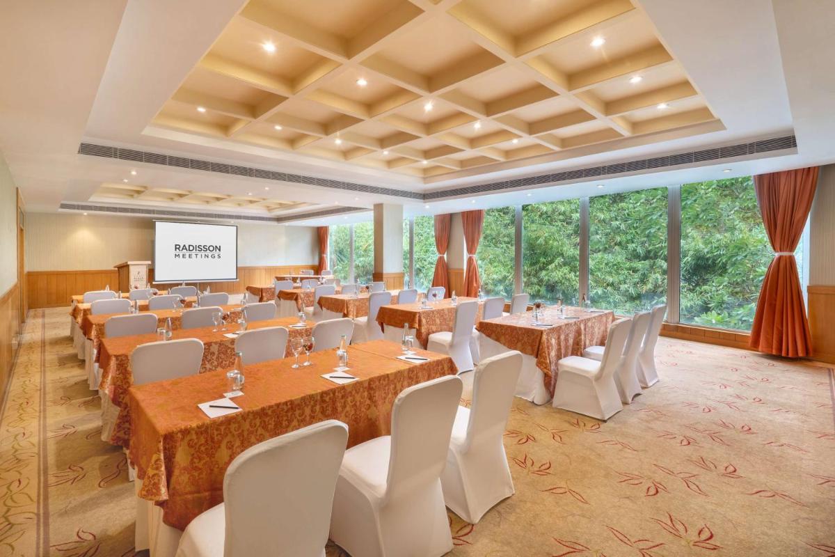 a large banquet room with tables and chairs and windows at Park Plaza Chennai OMR in Chennai