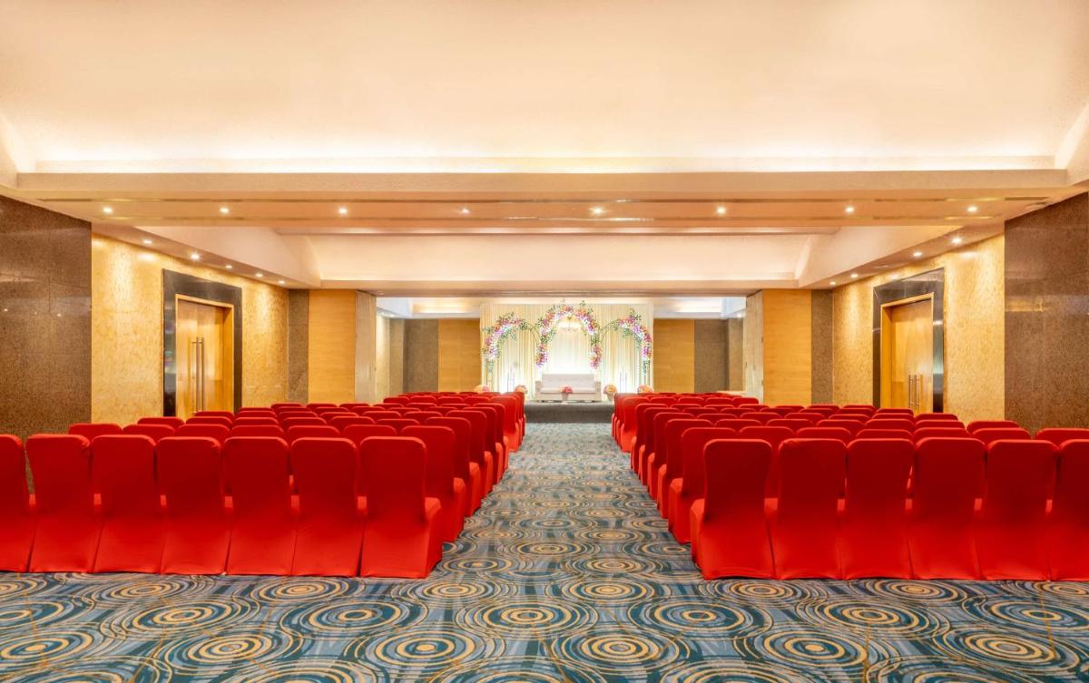an empty room with red chairs and a stage at Park Plaza Chennai OMR in Chennai