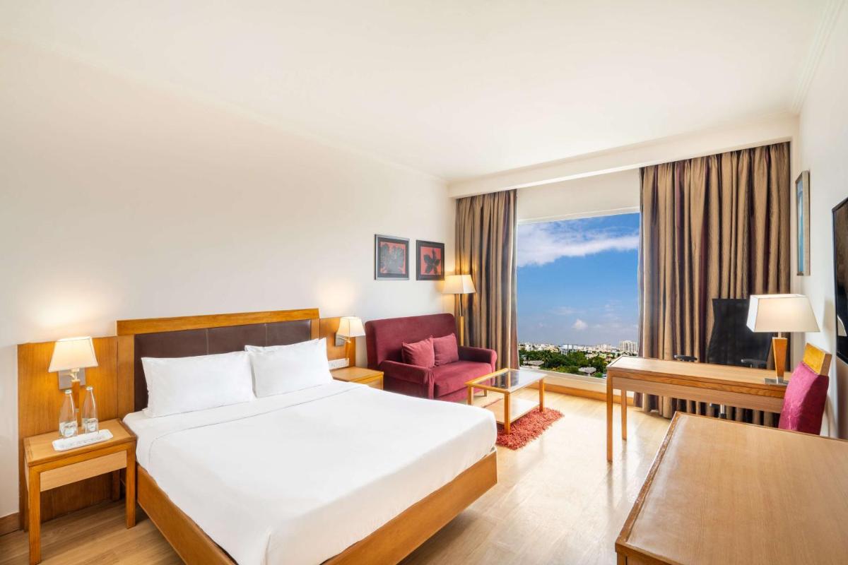 a hotel room with a bed and a window at Park Plaza Chennai OMR in Chennai