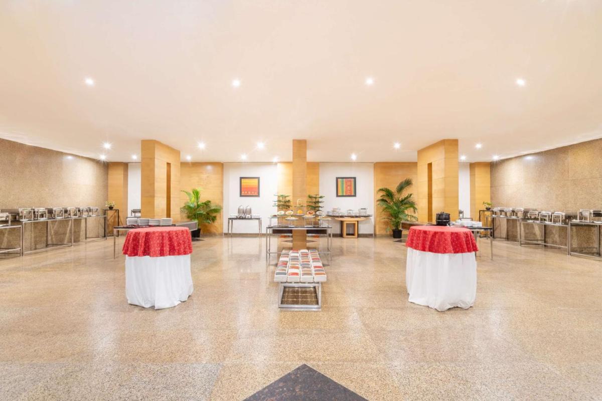 a large lobby with two tables with red and white skirts at Park Plaza Chennai OMR in Chennai