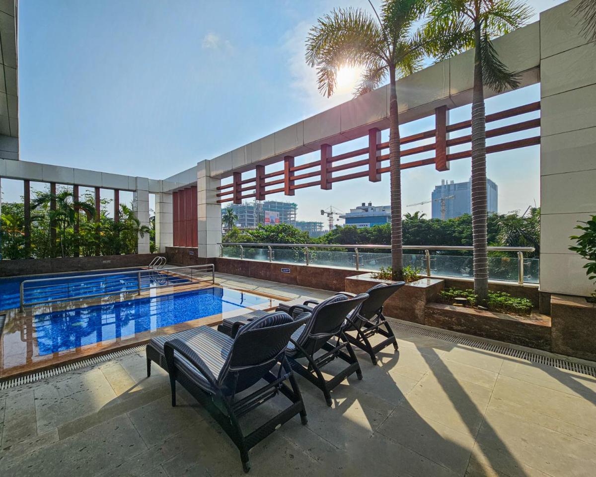 a patio with chairs and a swimming pool on a building at Novotel Chennai Sipcot in Chennai