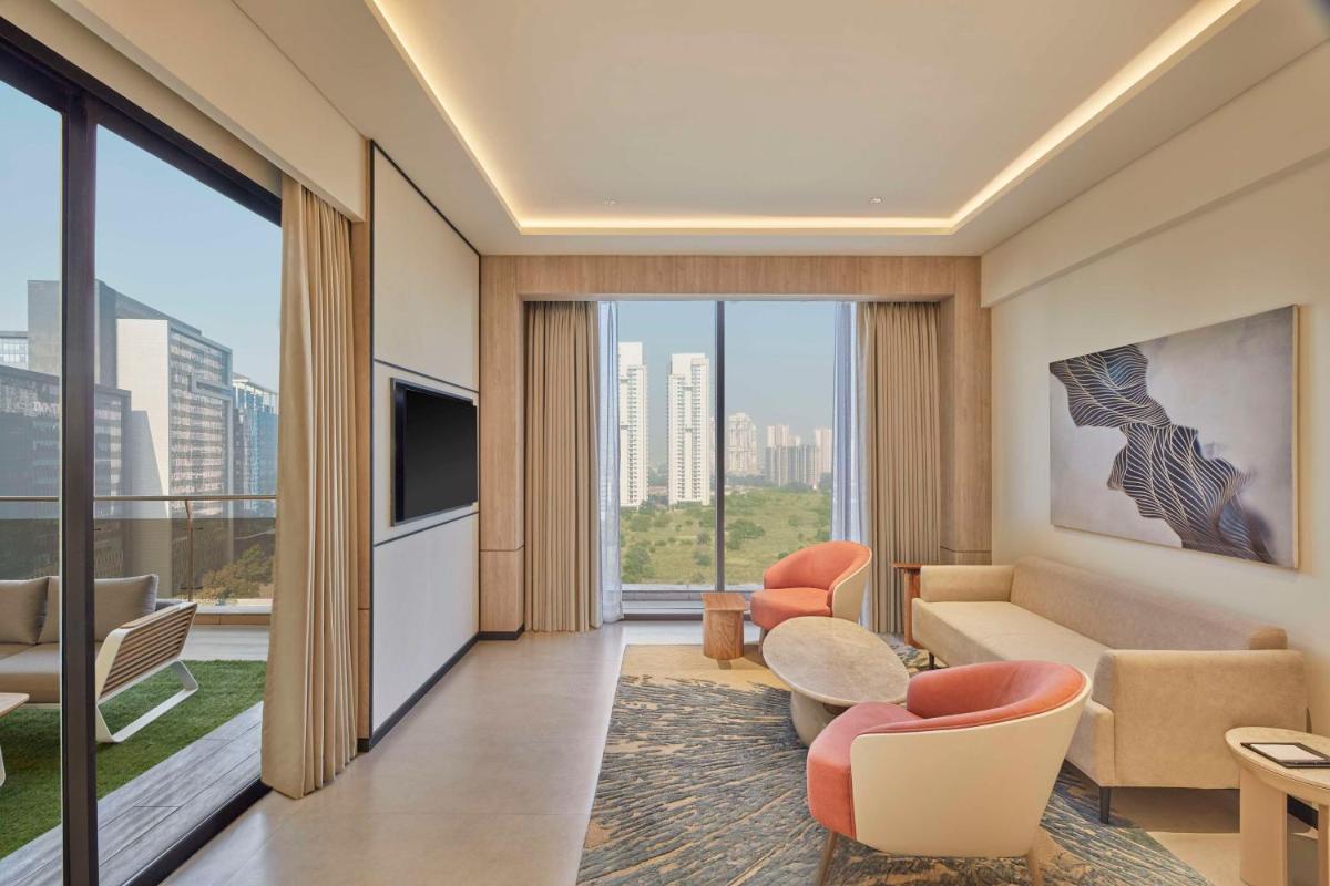 a living room with a couch and a tv at Hilton Gurugram Baani City Centre in Gurgaon