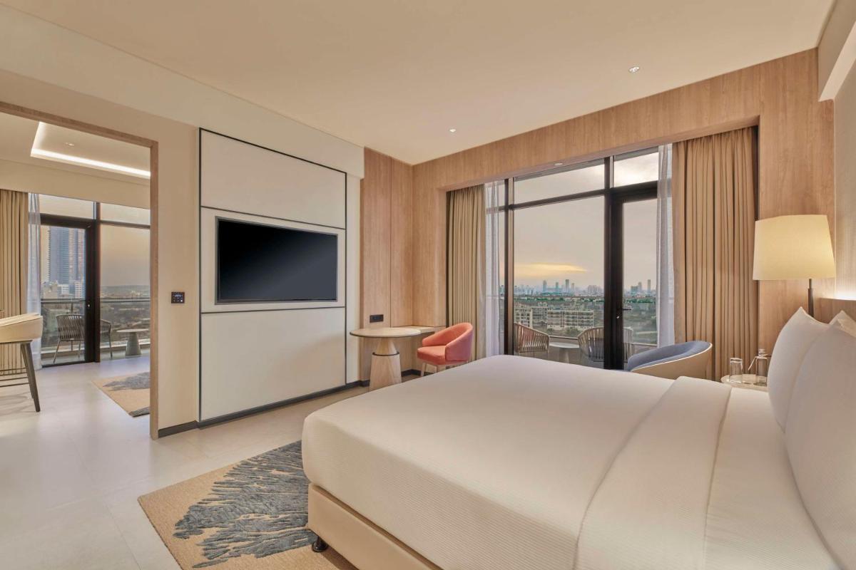 a hotel room with a bed and a television at Hilton Gurugram Baani City Centre in Gurgaon