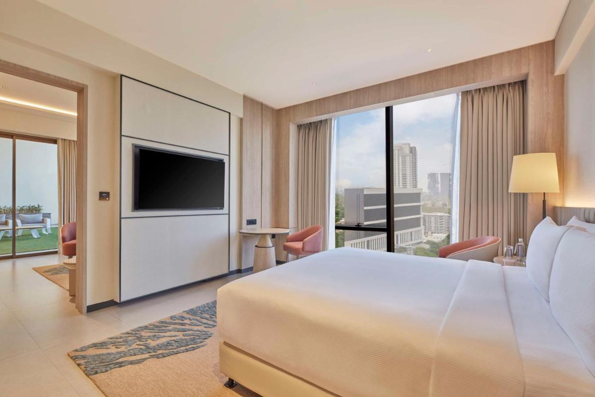 a hotel room with a large bed and a television at Hilton Gurugram Baani City Centre in Gurgaon