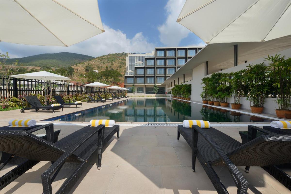a hotel swimming pool with chairs and a building at Marasa Sarovar Premiere in Tirupati