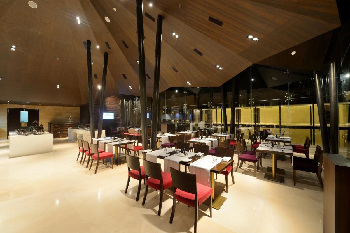 a restaurant with tables and chairs in a room at Marasa Sarovar Premiere in Tirupati