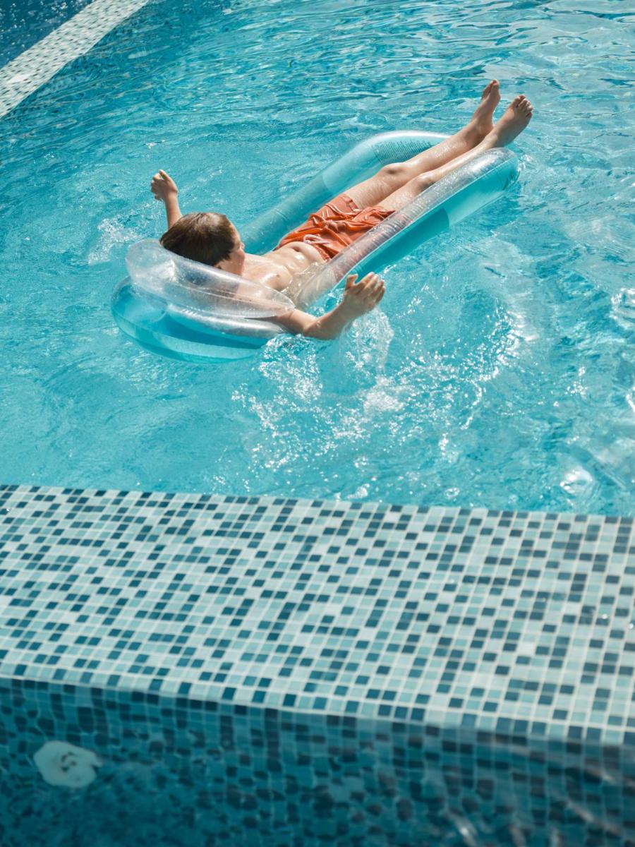 un niño tirado en una balsa en una piscina en Iberostar Selection Playa de Muro Village, en Playa de Muro