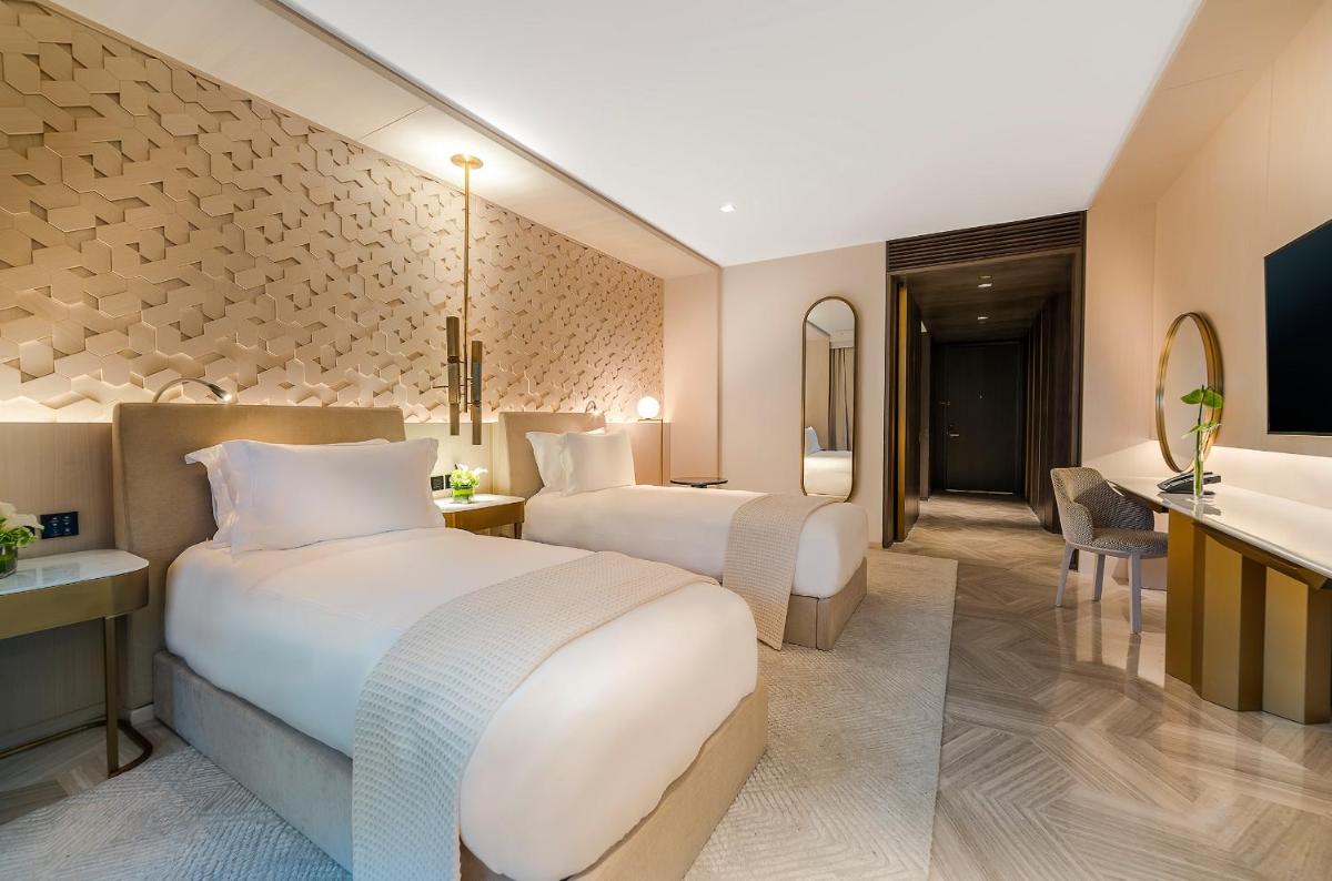 two beds in a hotel room with a bathroom at FIVE Palm Jumeirah Dubai in Dubai two beds in a hotel room with a bathroom at FIVE Palm Jumeirah Dubai in Dubai