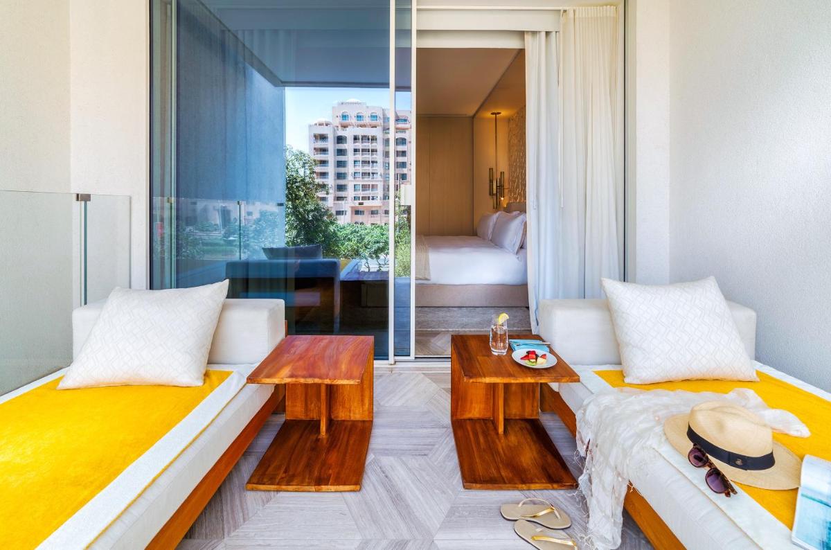 a living room with two beds and a table at FIVE Palm Jumeirah Dubai in Dubai