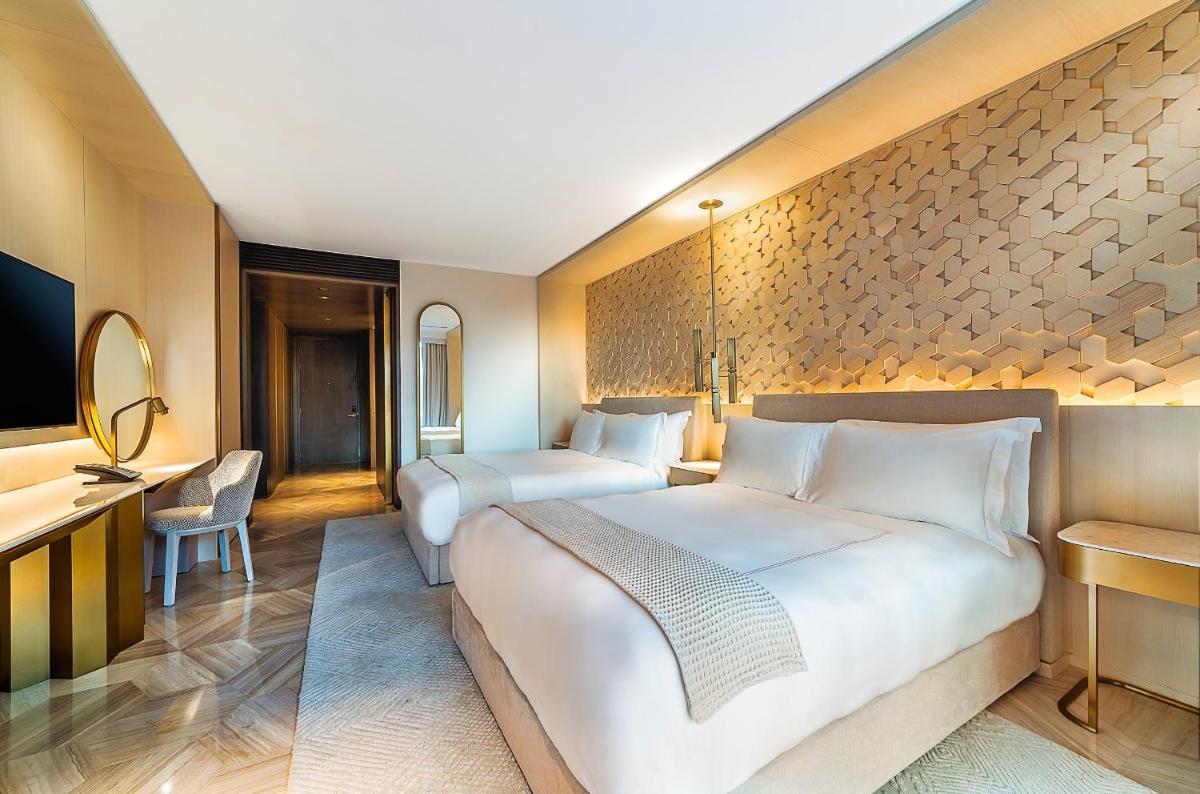 a hotel room with two beds and a desk at FIVE Palm Jumeirah Dubai in Dubai