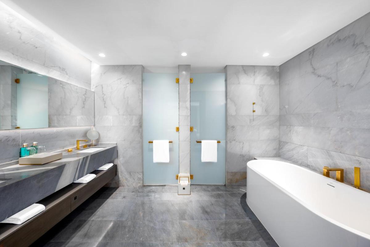a bathroom with a tub and two sinks and a bath tub at FIVE Palm Jumeirah Dubai in Dubai