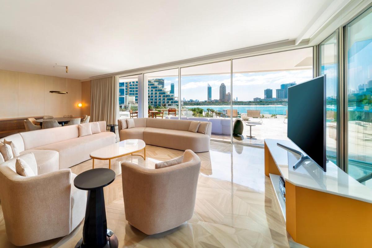 a living room with a couch and chairs and a television at FIVE Palm Jumeirah Dubai in Dubai