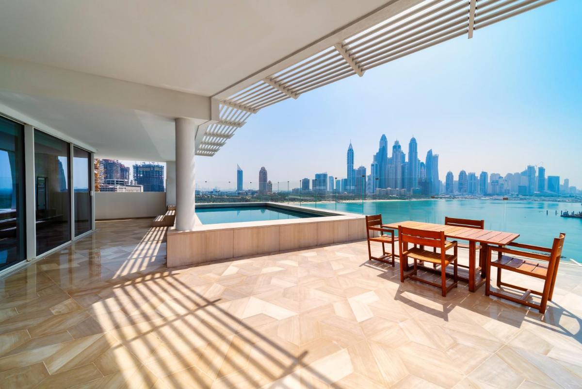 a balcony with a table and chairs and a view of the city at FIVE Palm Jumeirah Dubai in Dubai