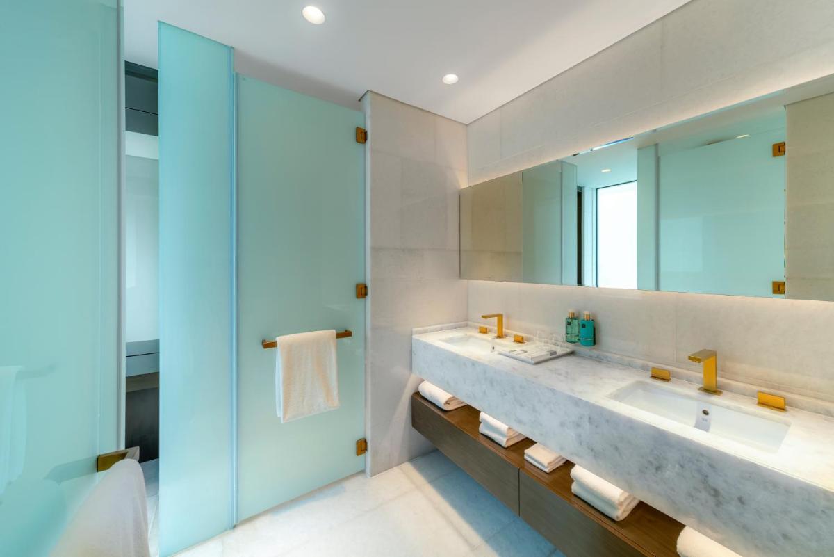 a bathroom with a sink and a large mirror at FIVE Palm Jumeirah Dubai in Dubai a bathroom with a sink and a large mirror at FIVE Palm Jumeirah Dubai in Dubai