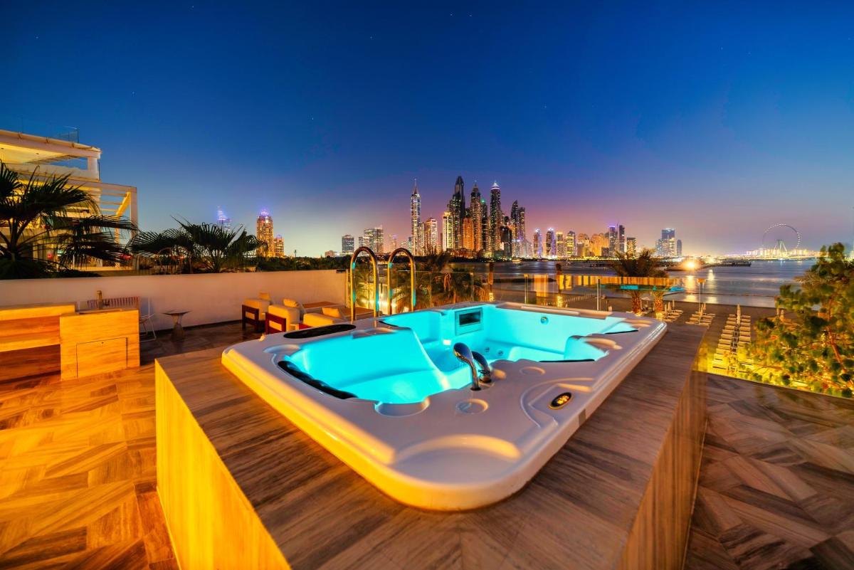 a hot tub on a deck with a city in the background at FIVE Palm Jumeirah Dubai in Dubai