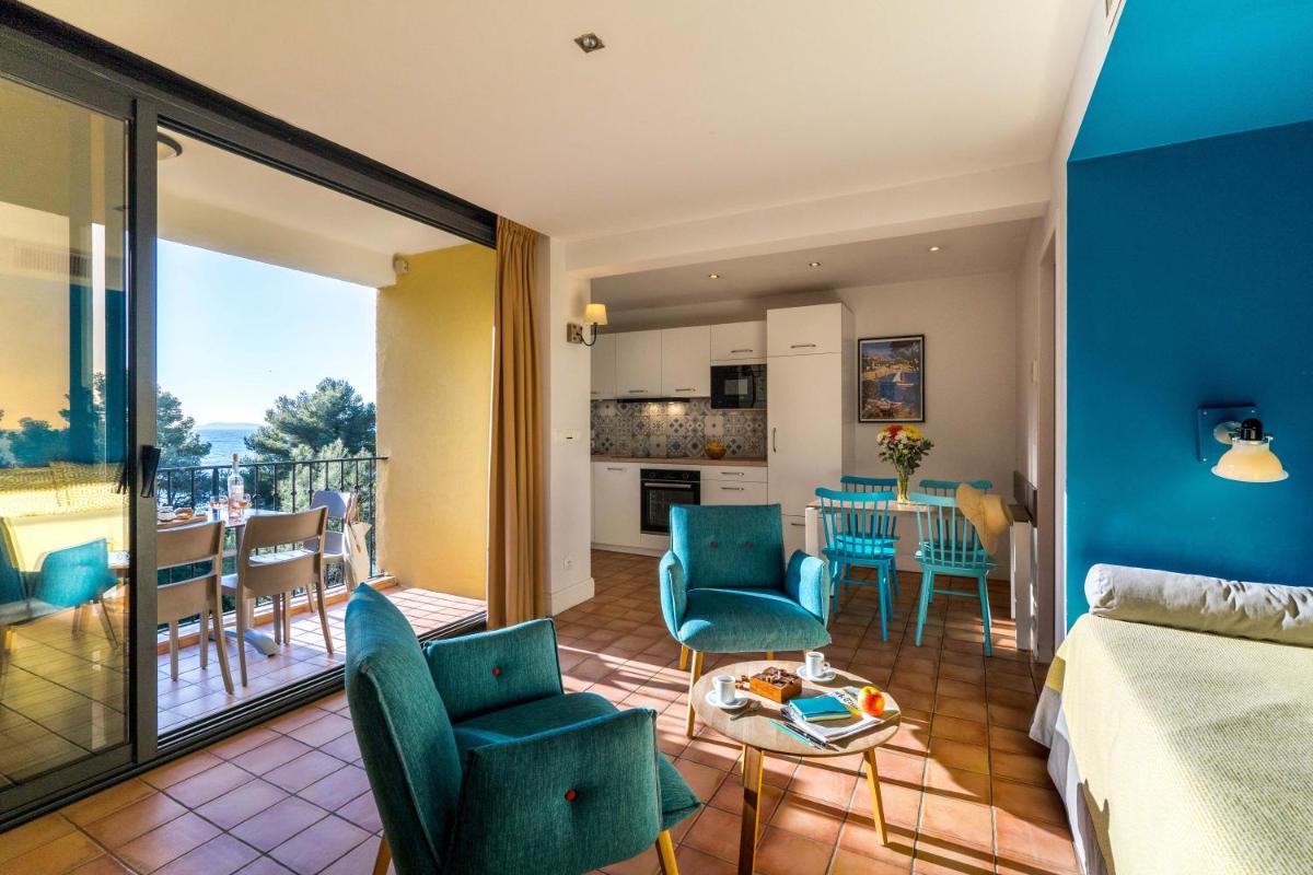 un salon avec un canapé et une table dans l'établissement La Résidence du Bailli, à Rayol-Canadel-sur-Mer