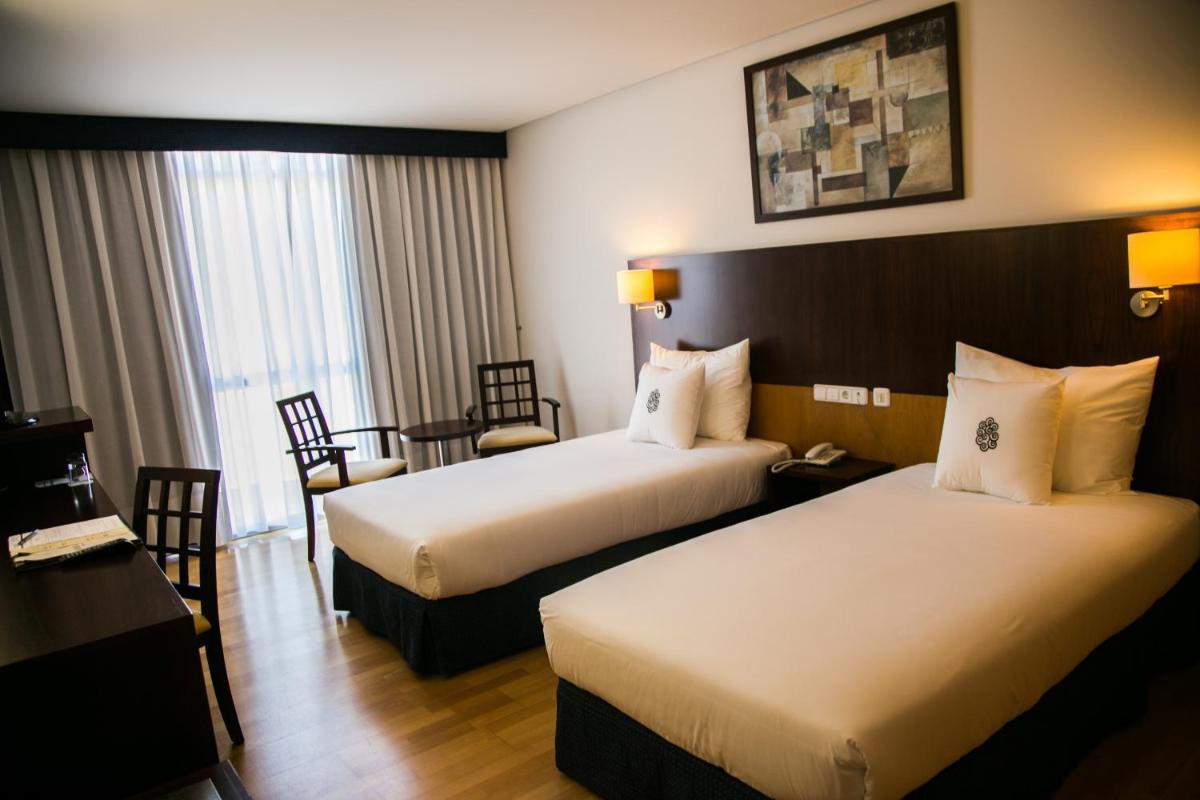 una habitación de hotel con dos camas y una mesa en Lobios Caldaria Hotel Balneario, en Bubaces