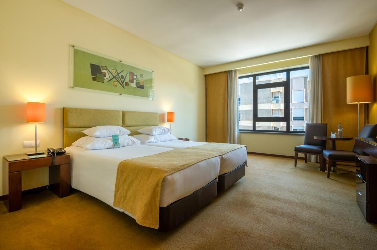 Uma cama ou camas num quarto em Vila Gale Coimbra