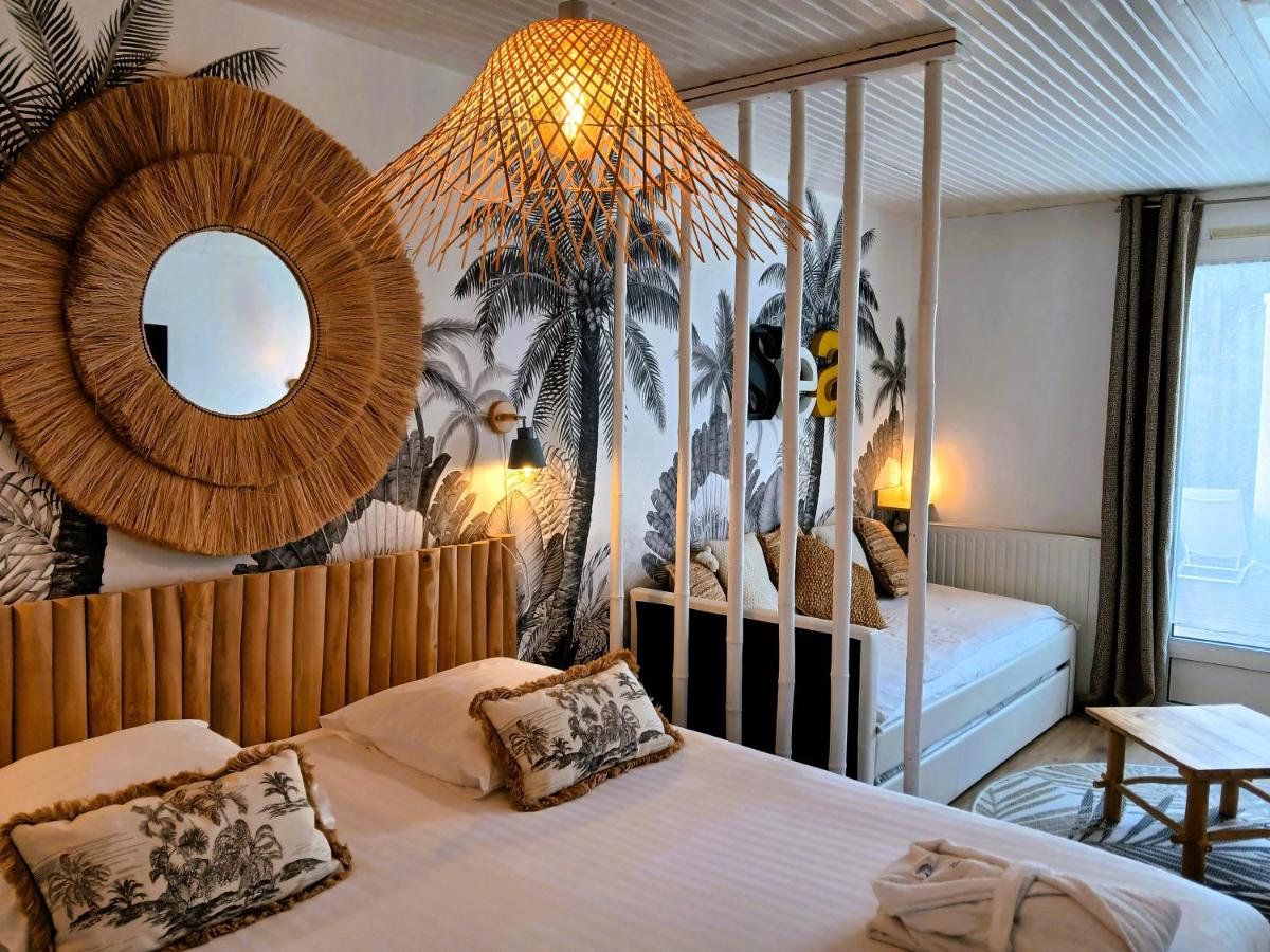 une chambre avec un lit à baldaquin et un miroir dans l'établissement Hôtel Ancre Marine & Spa Thalgo ***, à Noirmoutier-en-l'lle
