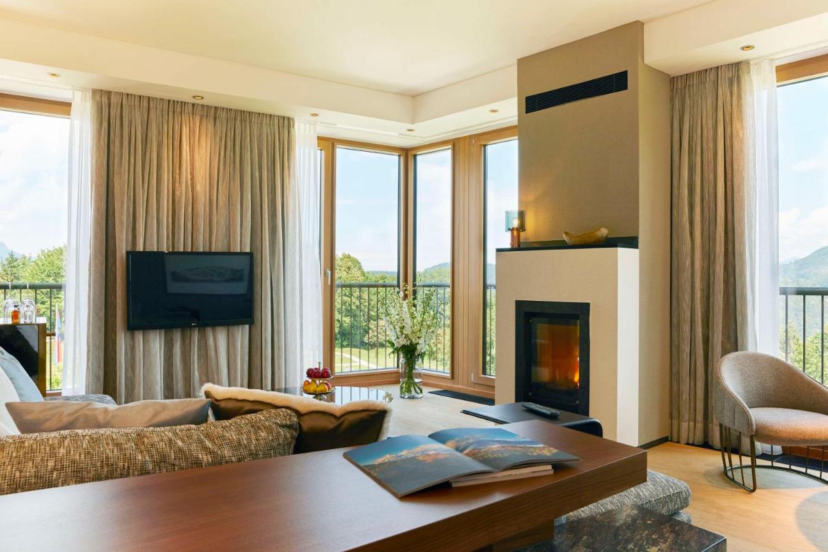 ein Wohnzimmer mit Sofa und Kamin in der Unterkunft Kempinski Hotel Berchtesgaden in Berchtesgaden + 109 Fotos